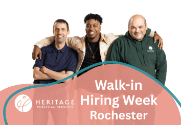 Three smiling men with arms around each other stand above a sign reading Walk-In Hiring Week, proudly representing Heritage Christian Services on a white background—an inviting glimpse into Rochester NY jobs and community opportunities.